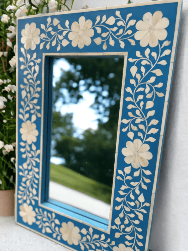 A mirror with blue and white flowers on it.