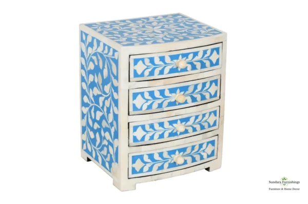 A blue and white three drawer chest with floral design.