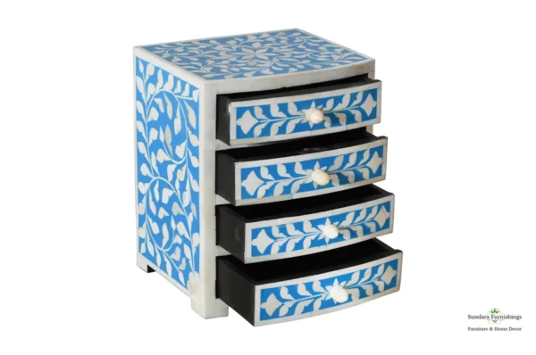 A blue and white four drawer chest with floral design.