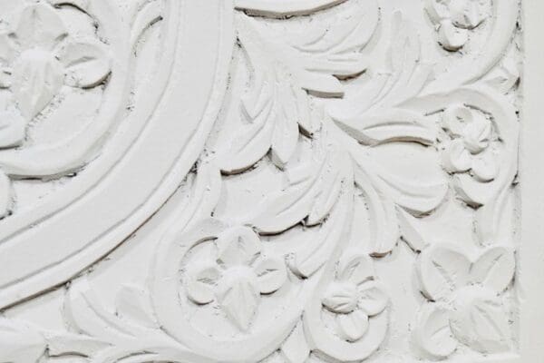 A close up of the ornate white carving on the wall.