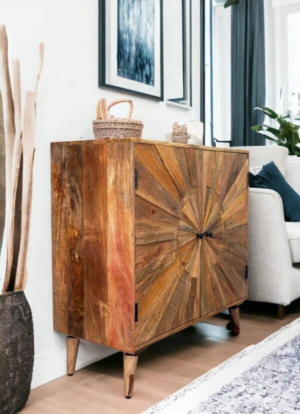 A solid wood cabinet with a sunburst design sitting in the middle of a living room.