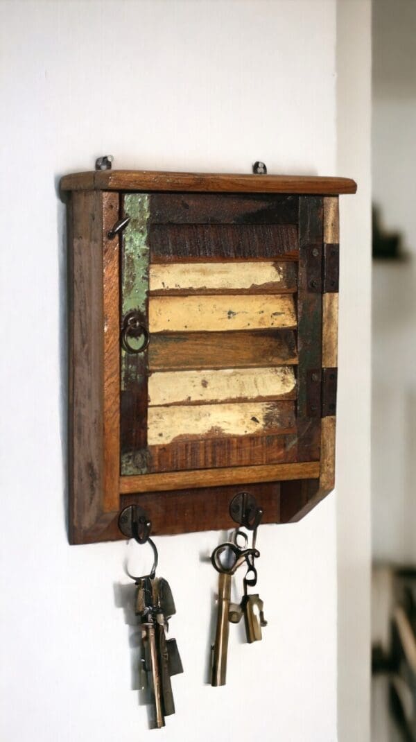 Rustic farmhouse-style key cupboard staged hanging on a white wall with keys in a home