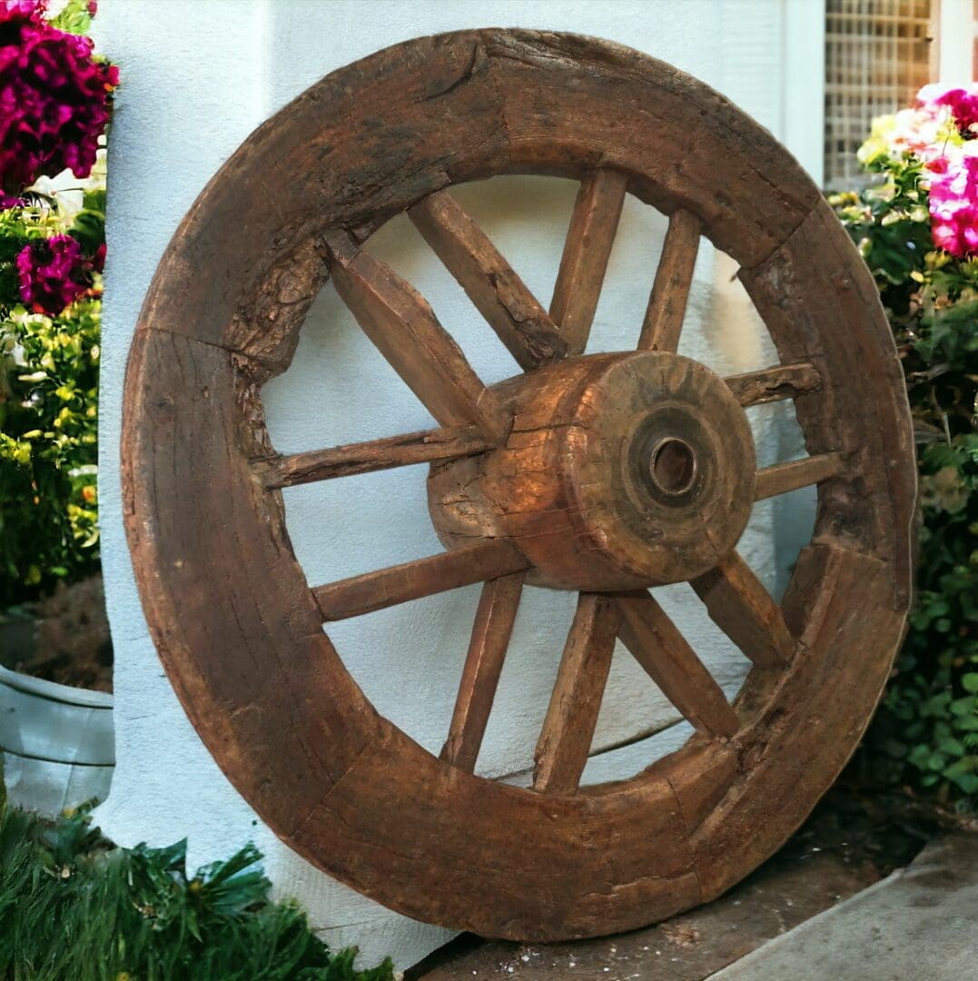 a vintage oxcart wagon wheel staged on a patio. 44" tall, 44" wide, 14.5" deep and 98lbs