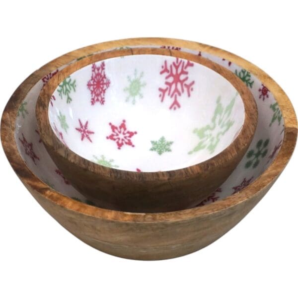 Set of two natural wood bowls with white inset with red and green snowflake motif on a white background