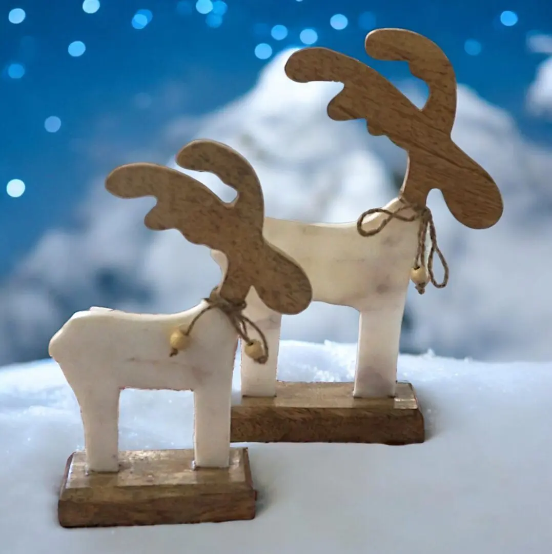 Set of two marble and wood reindeer staged in a snowy Christmas background