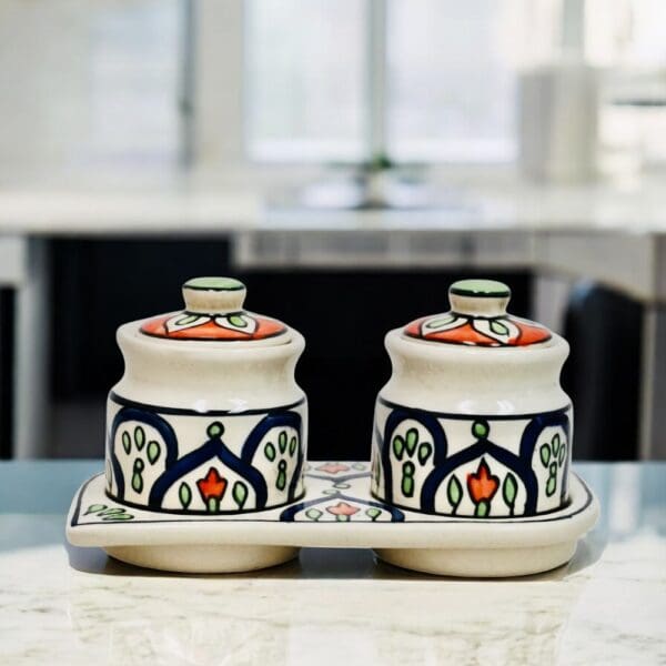 Hand-crafted traditionally used as Indian pickle or chutney jars this hand-painted set of two ceramic pots with lids and matching ceramic tray is a versatile addition for any home.