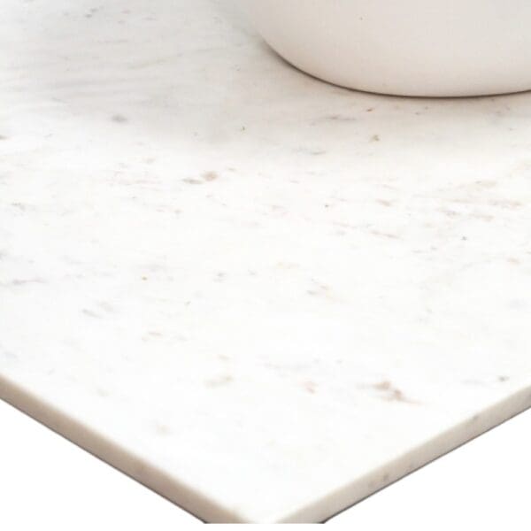 close up picture of marble top with bottom of basin shown in top right-hand side