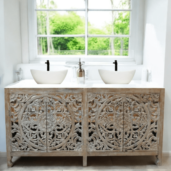 Hand-crafted solid mango wood double vanity with hand-carved doors, a marble top and two ceramic basins staged in a bathroom