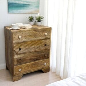 Hand-crafted 4-drawer dresser with hand-carved drawer fronts staged in a sunny bedroom.