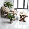 Hand-crafted wooden chair with matching footstool. Hand-woven seat, and backrest. Staged in a bight room.