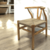 Natural wood wishbone back chair with natural rope seat in a home.