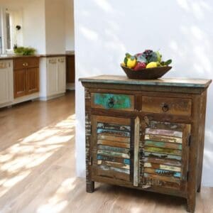 Hand-crafted reclaimed wood buffet cabinet with louvre doors and two drawers staged in a home