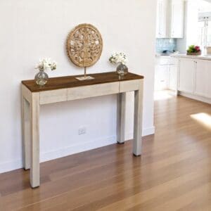 Hand-crafted solid wood console table with a hidden drawer in a rustic whitewashed finish and walnut finish top staged in an entryway.