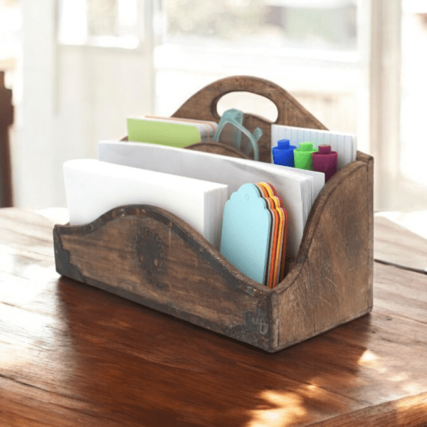 Vintage wood desk tidy staged with stationary on a sunny desk