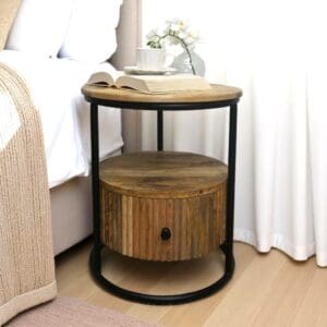 Hand-crafted round solid wood and iron accent table staged as a nightstand