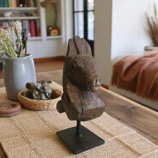 Hand-crafted antique primitive horse head stature staged on a living room table