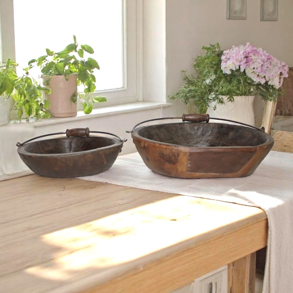 Set of two vintage wood bowls with handles staged on a kitchen counter