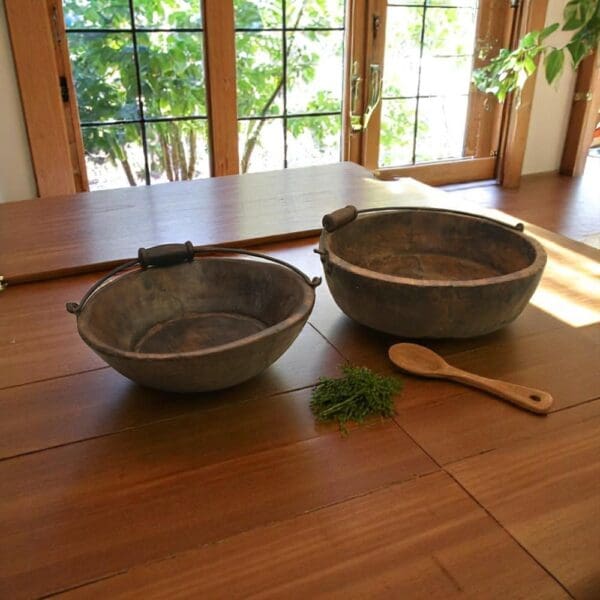 Set of 2 vintage wood bowls with handles staged in a rustic kitchen