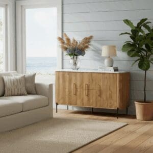 Hand-crafted fluted cabinet with marble top staged in a sunny coastal living room.